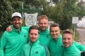 Piers Ward and Andy Proudman, along with two others, in green shirts posing for a picture at Augusta National Golf Course during the 2018 Masters.
